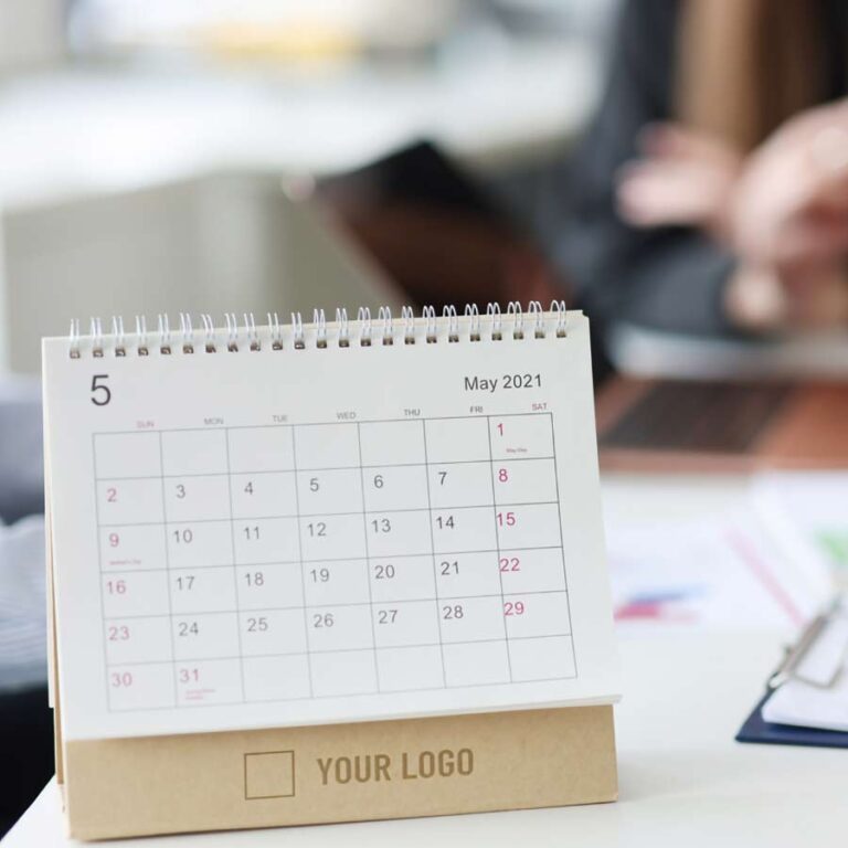 Branded calendar with a company logo sitting on a desk.